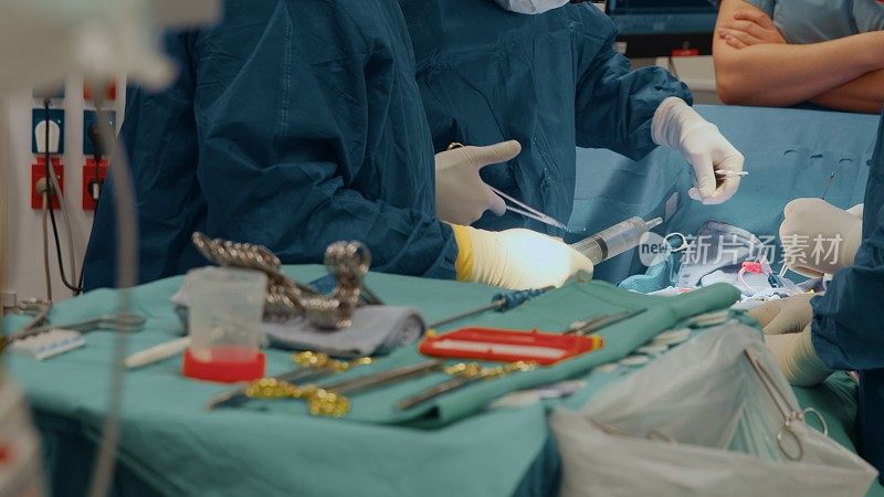 Surgeons wield a syringe and scissors during heart surgery